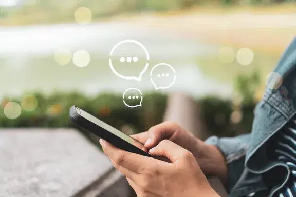 スマートフォンでチャットを確認する手元